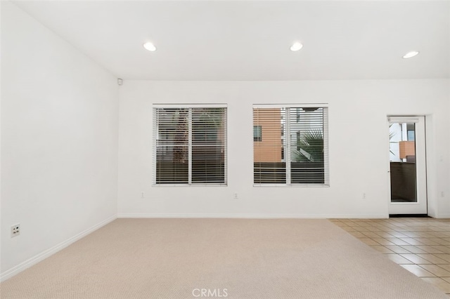 empty room featuring light tile patterned flooring, recessed lighting, light carpet, and baseboards