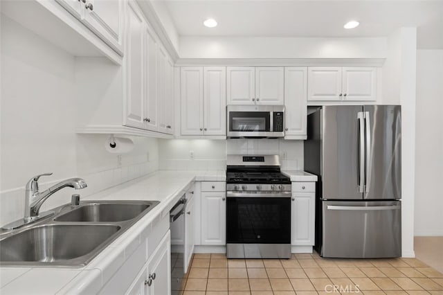 kitchen with light countertops, recessed lighting, white cabinets, stainless steel appliances, and a sink