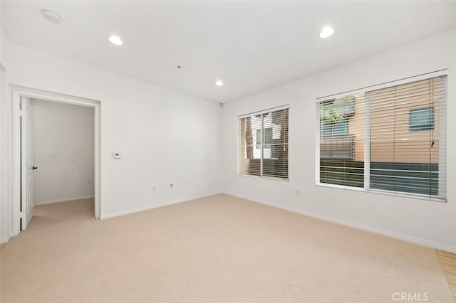 empty room with recessed lighting, baseboards, and light colored carpet