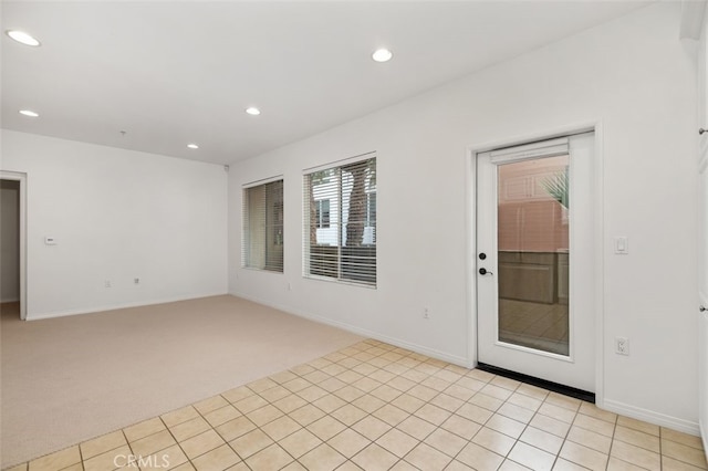 spare room with recessed lighting, light colored carpet, and baseboards