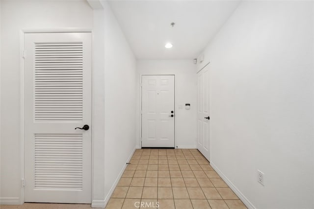 hallway featuring light tile patterned floors, recessed lighting, and baseboards