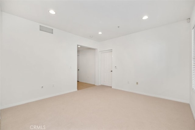 spare room featuring recessed lighting, visible vents, baseboards, and light colored carpet