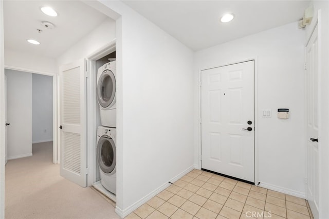 laundry area featuring recessed lighting, baseboards, laundry area, and stacked washer / dryer