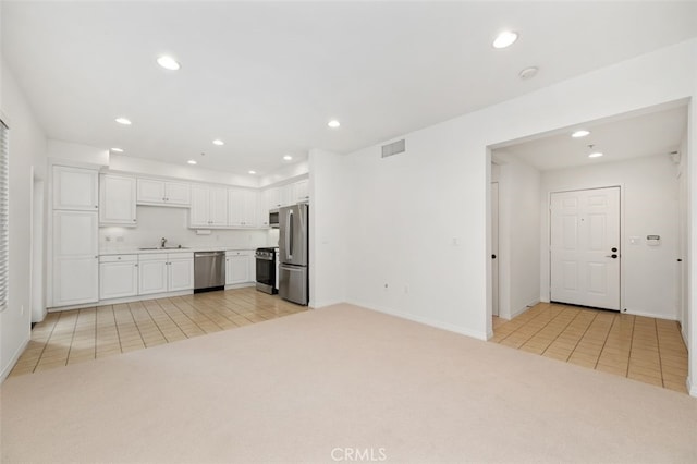 kitchen featuring visible vents, light carpet, recessed lighting, stainless steel appliances, and white cabinetry