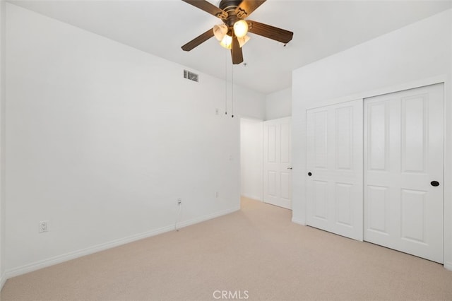 unfurnished bedroom with a ceiling fan, baseboards, visible vents, a closet, and light carpet