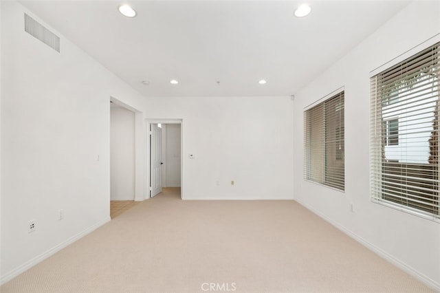 spare room with recessed lighting, visible vents, baseboards, and light colored carpet