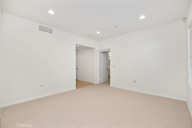 unfurnished room with recessed lighting, visible vents, baseboards, and light colored carpet