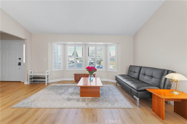 living room featuring wood finished floors, baseboards, and lofted ceiling