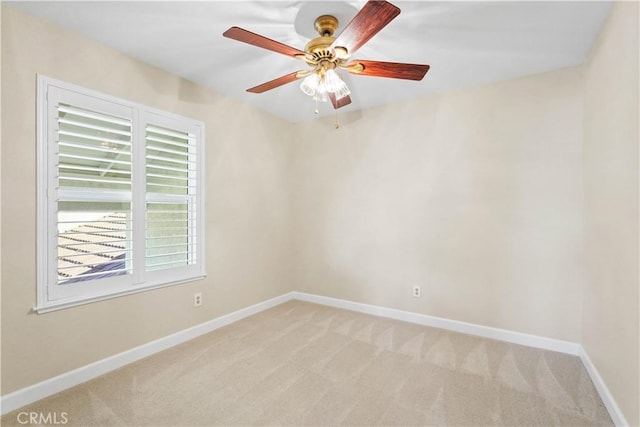 empty room with light colored carpet, baseboards, and ceiling fan