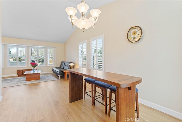 dining space featuring baseboards, light wood-style floors, and a chandelier