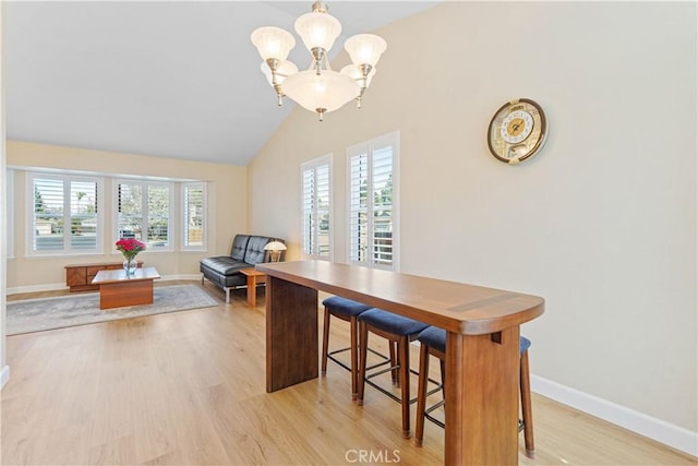 dining room featuring baseboards, a notable chandelier, and light wood-style floors