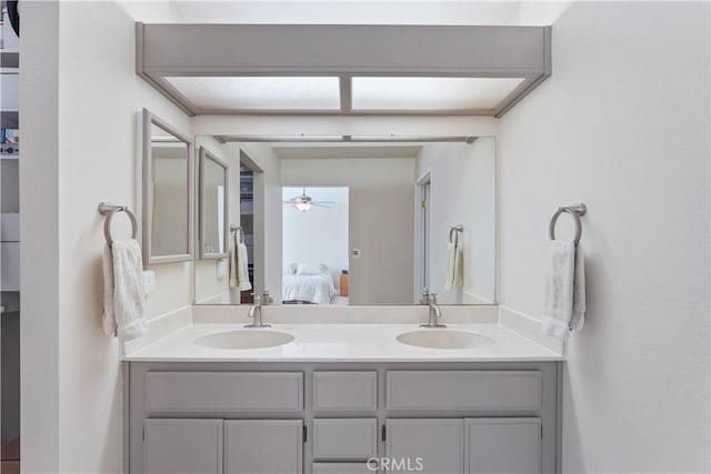 ensuite bathroom featuring a sink, double vanity, ceiling fan, and ensuite bathroom