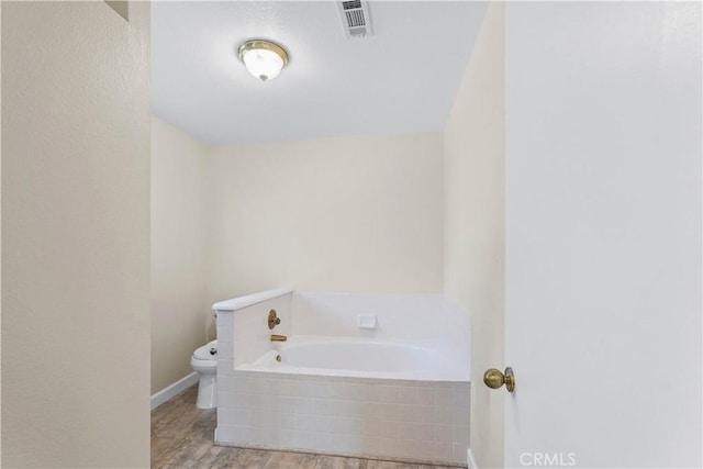 bathroom with visible vents, toilet, and a bath