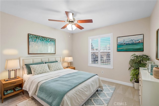 bedroom with ceiling fan, light colored carpet, and baseboards