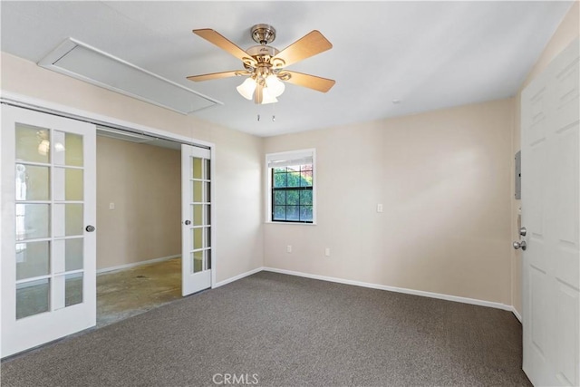 unfurnished room with french doors, carpet, baseboards, attic access, and ceiling fan