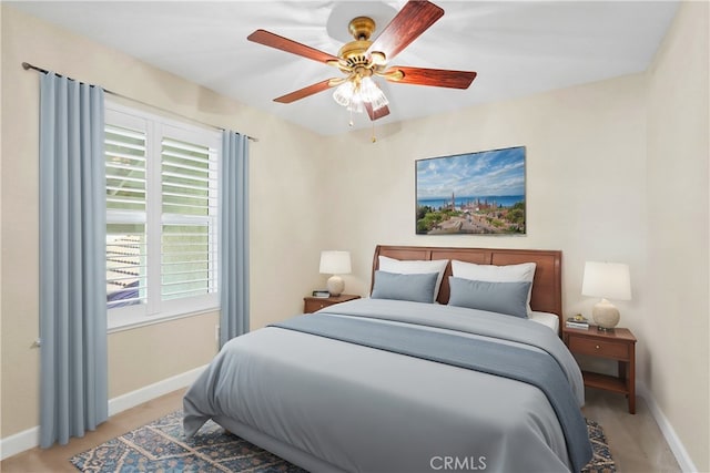 bedroom with light carpet, ceiling fan, and baseboards