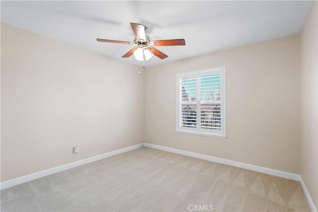 unfurnished room featuring light carpet, baseboards, and ceiling fan