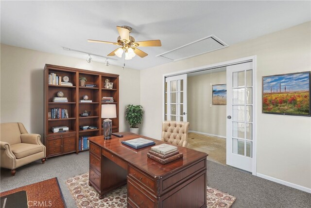 office featuring attic access, light carpet, baseboards, and ceiling fan