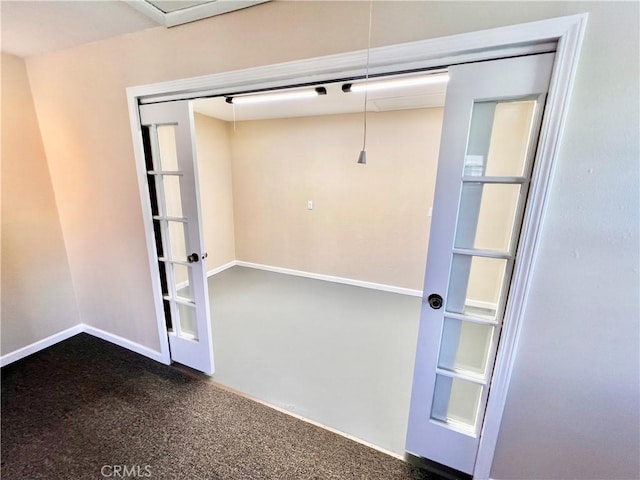 empty room featuring dark carpet and baseboards