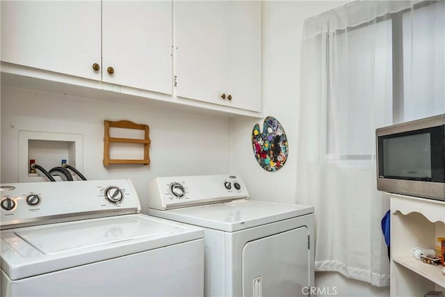 washroom with cabinet space and washer and dryer