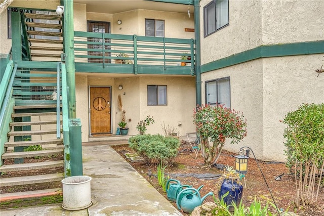 doorway to property featuring a balcony and stucco siding