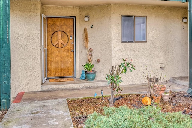 view of exterior entry featuring stucco siding