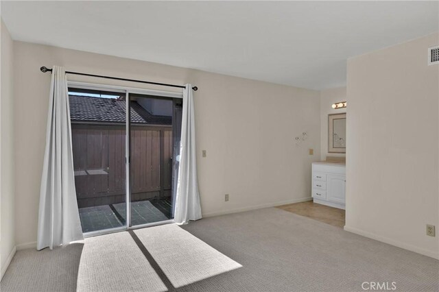 unfurnished bedroom featuring carpet flooring, baseboards, visible vents, and access to outside