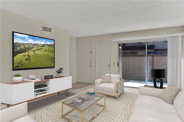 living area with visible vents, carpet floors, and a textured ceiling