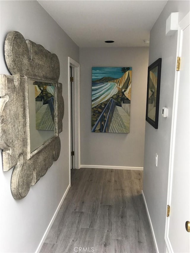 hall featuring wood finished floors and baseboards