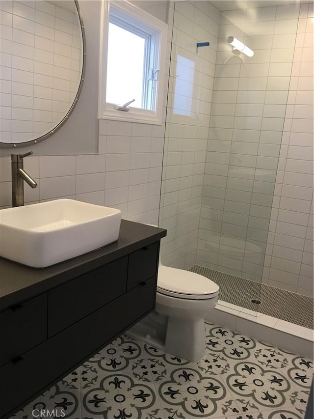 full bathroom featuring tile patterned floors, tile walls, a stall shower, and vanity