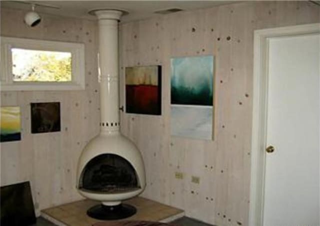 unfurnished living room with wood walls