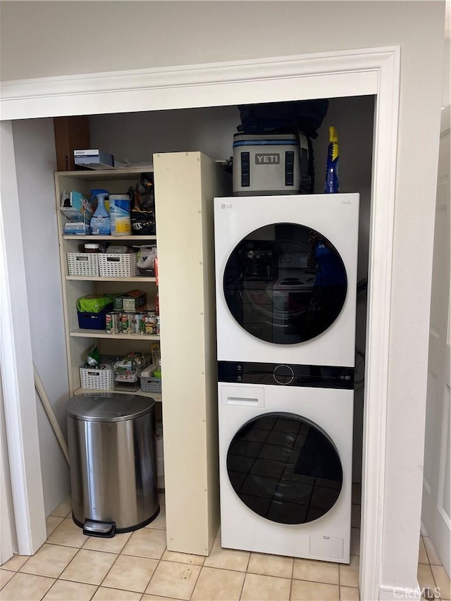 washroom with stacked washer and clothes dryer and light tile patterned floors