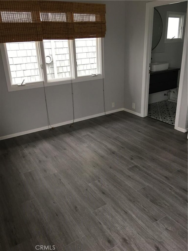 unfurnished room featuring dark wood finished floors and baseboards