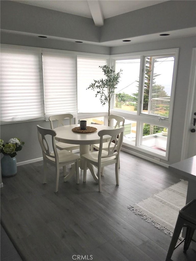 dining room with healthy amount of natural light, wood finished floors, and beamed ceiling