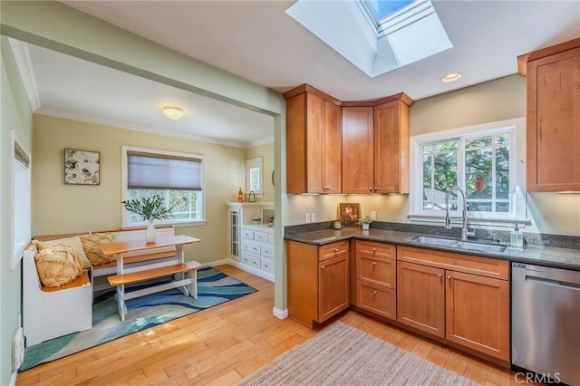 kitchen with a sink, light wood-type flooring, brown cabinets, and stainless steel dishwasher