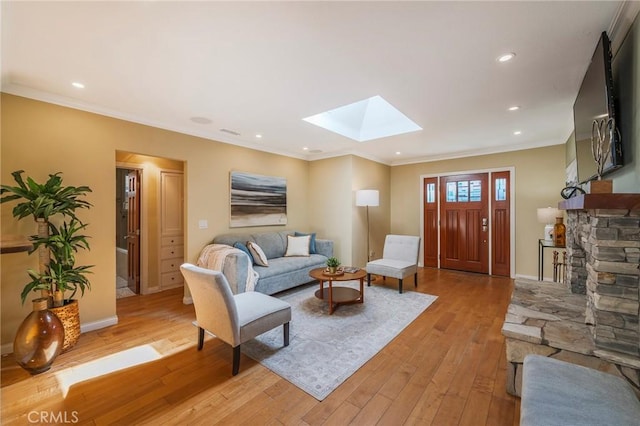 living room with light wood-type flooring, crown molding, baseboards, and a skylight