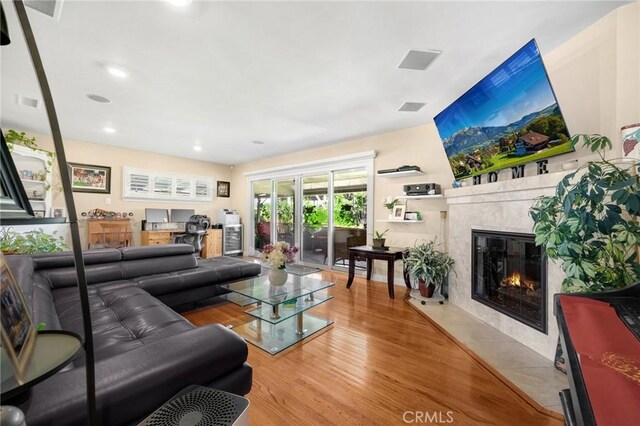 living area featuring visible vents, wood finished floors, and a fireplace