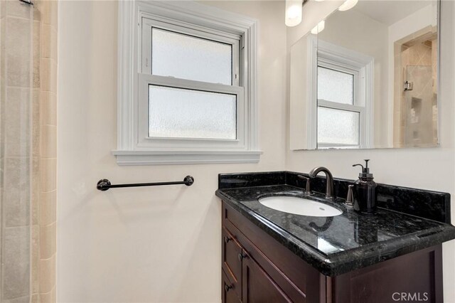 full bath featuring vanity and a tile shower