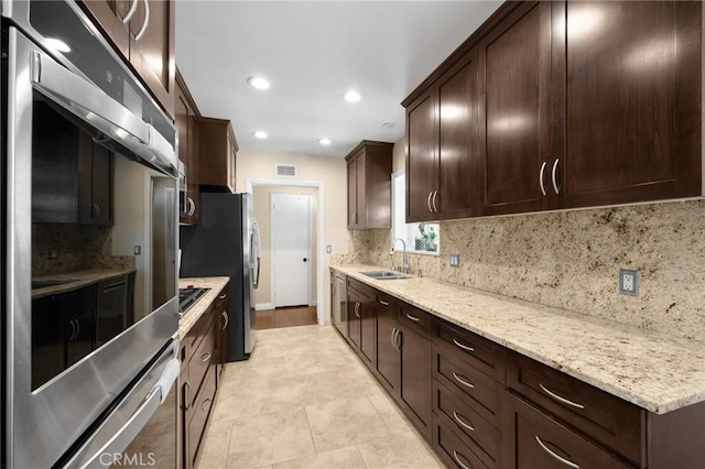 kitchen with visible vents, light tile patterned flooring, a sink, decorative backsplash, and dark brown cabinetry