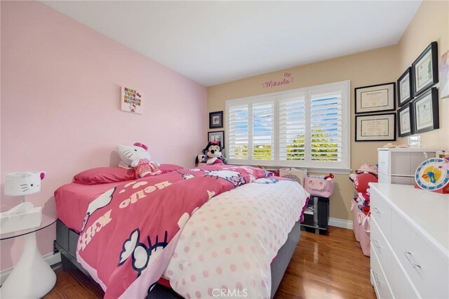 bedroom with baseboards and wood finished floors