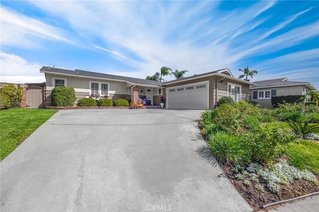 ranch-style home featuring an attached garage, concrete driveway, and a front lawn