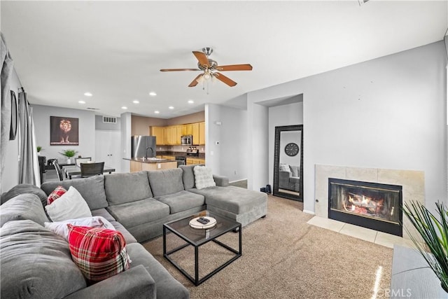 living area with light carpet, visible vents, a tile fireplace, ceiling fan, and recessed lighting