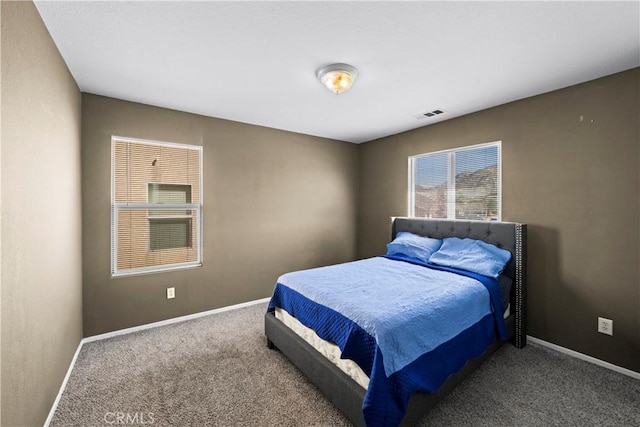 bedroom with carpet floors, visible vents, and baseboards