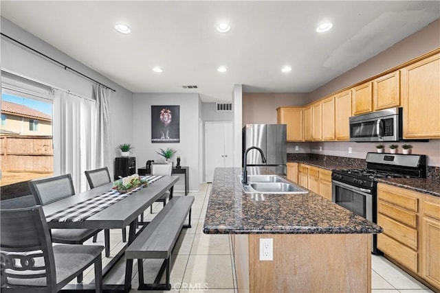 kitchen featuring a center island with sink, visible vents, light brown cabinetry, appliances with stainless steel finishes, and a sink