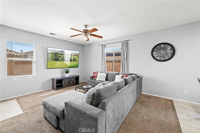 living area with ceiling fan, visible vents, and baseboards