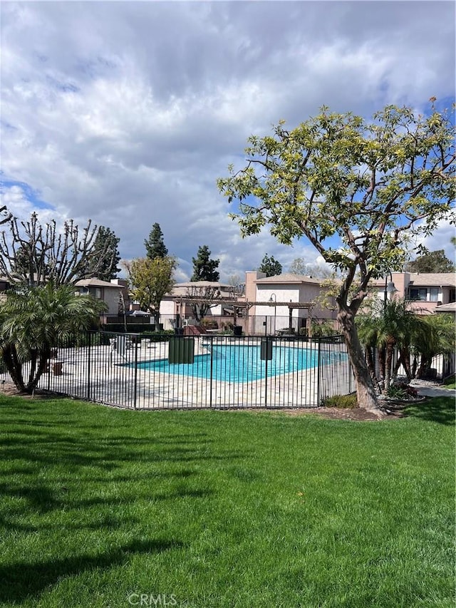 community pool with a lawn and fence