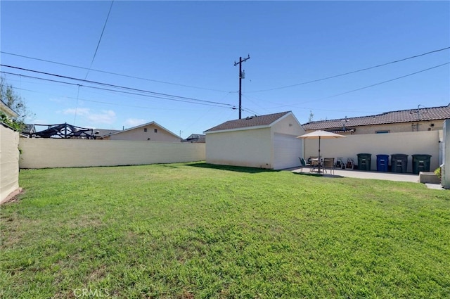 view of yard with an outbuilding, a patio, and a fenced backyard