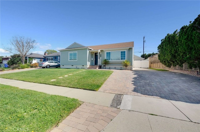 view of front of house featuring decorative driveway, crawl space, fence, and a front lawn