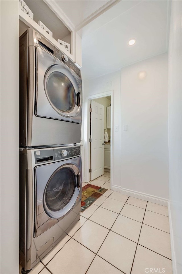 laundry room featuring light tile patterned floors, laundry area, baseboards, stacked washing maching and dryer, and recessed lighting