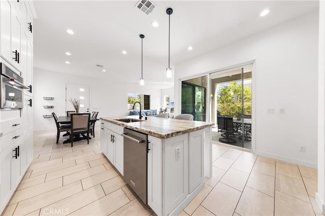 kitchen featuring a center island with sink, stainless steel appliances, a sink, and recessed lighting